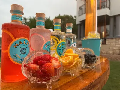 a table with bottles of alcohol and bowls of fruit at 156 Euphoria Boutique Villa - Euphoria Golf Estate Hydro in Naboomspruit