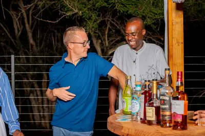 a man standing next to a table with bottles of booze at 156 Euphoria Boutique Villa - Euphoria Golf Estate Hydro in Naboomspruit
