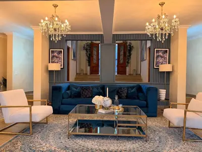 a living room with a blue couch and chairs at 156 Euphoria Boutique Villa - Euphoria Golf Estate Hydro in Naboomspruit