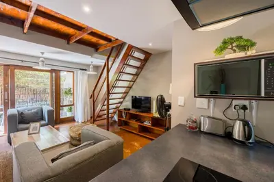 a living room with a flat screen tv and a couch at Raptors Wildlife Escapes in Hoedspruit