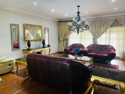 a living room with a couch and a chandelier at The Adress in Midrand