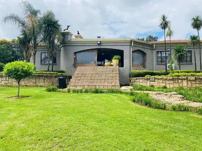 a house with palm trees in front of a yard at The Adress in Midrand