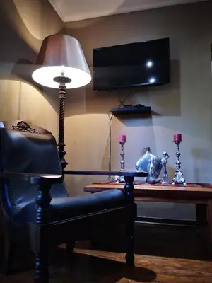 a desk with a lamp and a chair next to a table at Dublin Guest House in Sabie