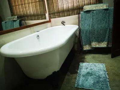 a white bath tub in a bathroom with a mirror at Dublin Guest House in Sabie
