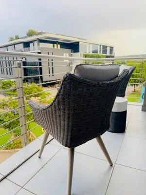 a wicker chair sitting on top of a balcony at French love, Menlyn Maine in Pretoria