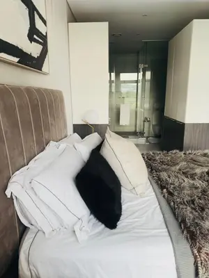 a bed with white pillows on top of it at French love, Menlyn Maine in Pretoria