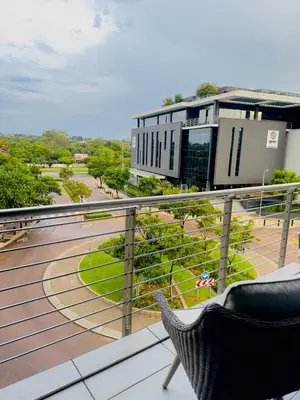 a balcony with a chair and a building at French love, Menlyn Maine in Pretoria