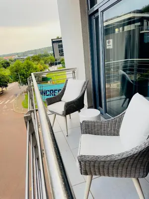a balcony with chairs and a table on a building at French love, Menlyn Maine in Pretoria