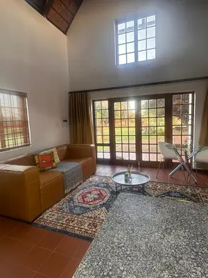 a living room with a couch and a table at The loft farmhouse in Roodeplaat area in Wallmannstal