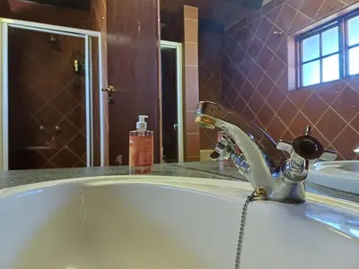 a bathroom with a bath tub with a faucet at The loft farmhouse in Roodeplaat area in Wallmannstal