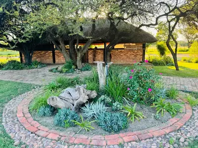 a garden with a circle of plants in front of a building at The loft farmhouse in Roodeplaat area in Wallmannstal