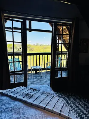 a bedroom with a bed and a view of a balcony at The loft farmhouse in Roodeplaat area in Wallmannstal