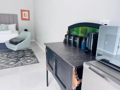a kitchen with a table with a laptop on a counter at Nelspruit Modern Apartment #2 - Self Check-In in Nelspruit
