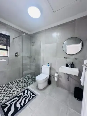 a bathroom with a toilet and a sink and a shower at Nelspruit Modern Apartment #2 - Self Check-In in Nelspruit