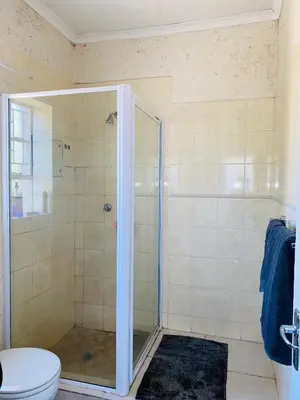 a bathroom with a glass shower with a toilet at Phana Quest house in Evander