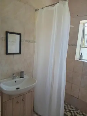 a bathroom with a sink and a shower curtain at Phana Quest house in Evander