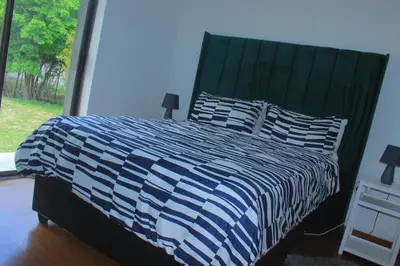 a bedroom with a bed with a blue and white comforter at Phana Quest house in Evander