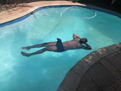 a dog laying in a swimming pool at 4 Seasons Country Club in Vosburg