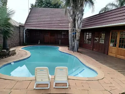 two chairs and a swimming pool with a house at 4 Seasons Country Club in Vosburg