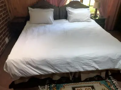 a large bed with white sheets and pillows at 4 Seasons Country Club in Vosburg