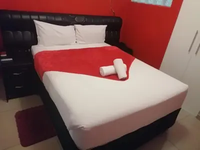 a bedroom with a bed with a black frame and a red wall at 4 Seasons Country Club in Vosburg