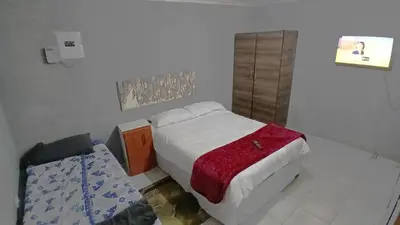 a small bedroom with a bed with a red blanket at Elim Pink House Accommodation in Elim