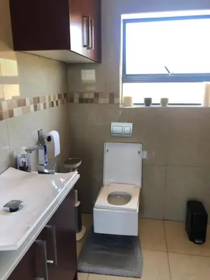 a small bathroom with a toilet and a sink at Nyumbani in Kempton Park