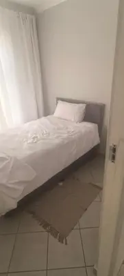 a bed in a room with a pillow on the floor at Lerato's Guesthouse 840 in Polokwane