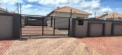 a gate in front of a house with a brick driveway at Lerato's Guesthouse 840 in Polokwane