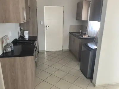 a small kitchen with a sink and a refrigerator at Lerato's Guesthouse 840 in Polokwane
