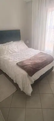 a bed sitting in a bedroom next to a window at Lerato's Guesthouse 840 in Polokwane