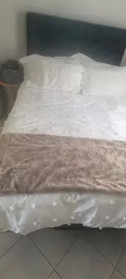 a bed with white sheets and a brown blanket at Lerato's Guesthouse 840 in Polokwane