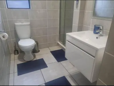 a bathroom with a white toilet and a sink at Apartment at The Blyde in Pretoria