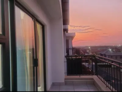 a balcony with a view of a sunset at Apartment at The Blyde in Pretoria