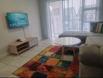a living room with a couch and a table at Apartment at The Blyde in Pretoria