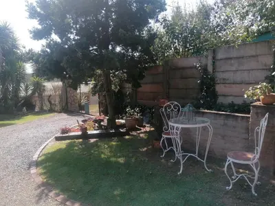 a garden with two chairs and a table and a tree at KINGFISHER BLUE on Milkwood in Sabie