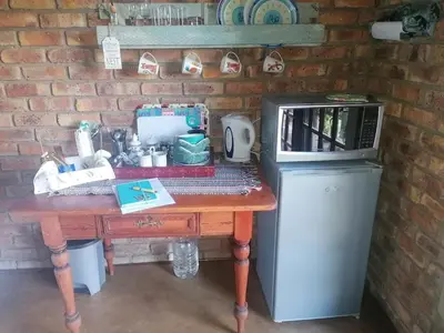 a table with a microwave on top of a brick wall at KINGFISHER BLUE on Milkwood in Sabie