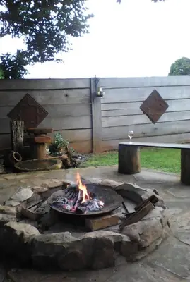 a fire pit in a yard next to a bench at KINGFISHER BLUE on Milkwood in Sabie