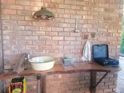a brick wall with a table with a bowl and a radio at KINGFISHER BLUE on Milkwood in Sabie