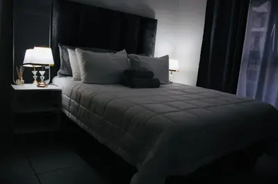 a bedroom with a large bed with a black headboard at The blyde crystal lagoon 116 in Pretoria