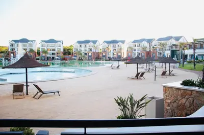 a swimming pool with chairs and umbrellas in a resort at The blyde crystal lagoon 116 in Pretoria