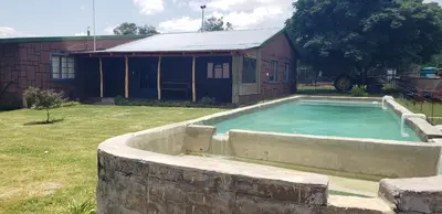a swimming pool in a stone wall next to a building at Berchtesgaden Lifestyle Farm - Farmstay in Vaalwater