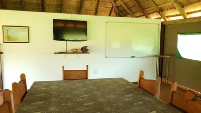a room with a table and a tv on the wall at Berchtesgaden Lifestyle Farm - Farmstay in Vaalwater