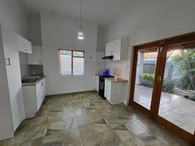 a kitchen with white cabinets and a tile floor at Meteor inn in Polokwane