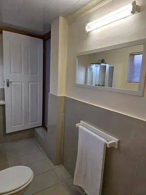 a bathroom with a white toilet and a mirror at Meteor inn in Polokwane