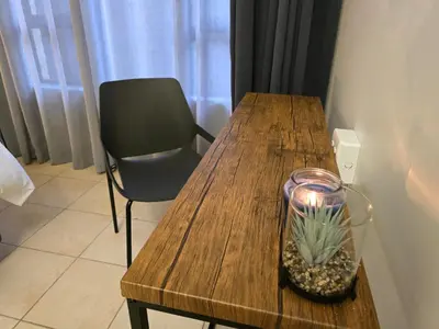 a wooden table with a candle in a glass jar at Meteor inn in Polokwane