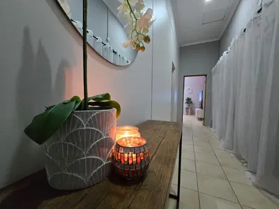 a hallway with a wooden table with a vase on it at Meteor inn in Polokwane