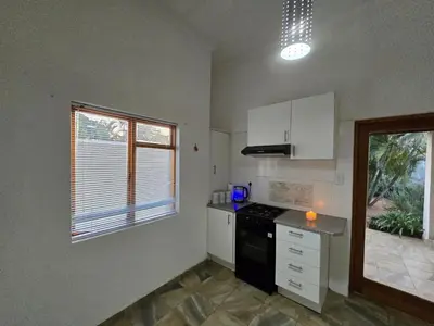 a kitchen with white cabinets and a black appliances at Meteor inn in Polokwane