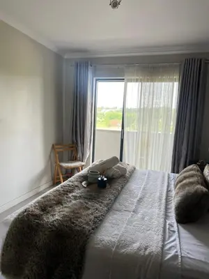 a bedroom with a large bed with a window at Nane's Tranquil Retreat in Midrand