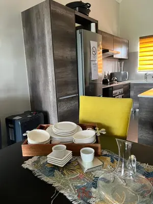a kitchen with a table with plates and dishes on it at Nane's Tranquil Retreat in Midrand